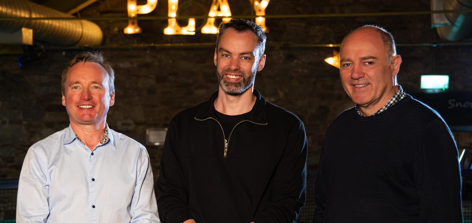 Billy Kirwan and colleagues at the Mardyke Entertainment Complex under a lit PLAY sign