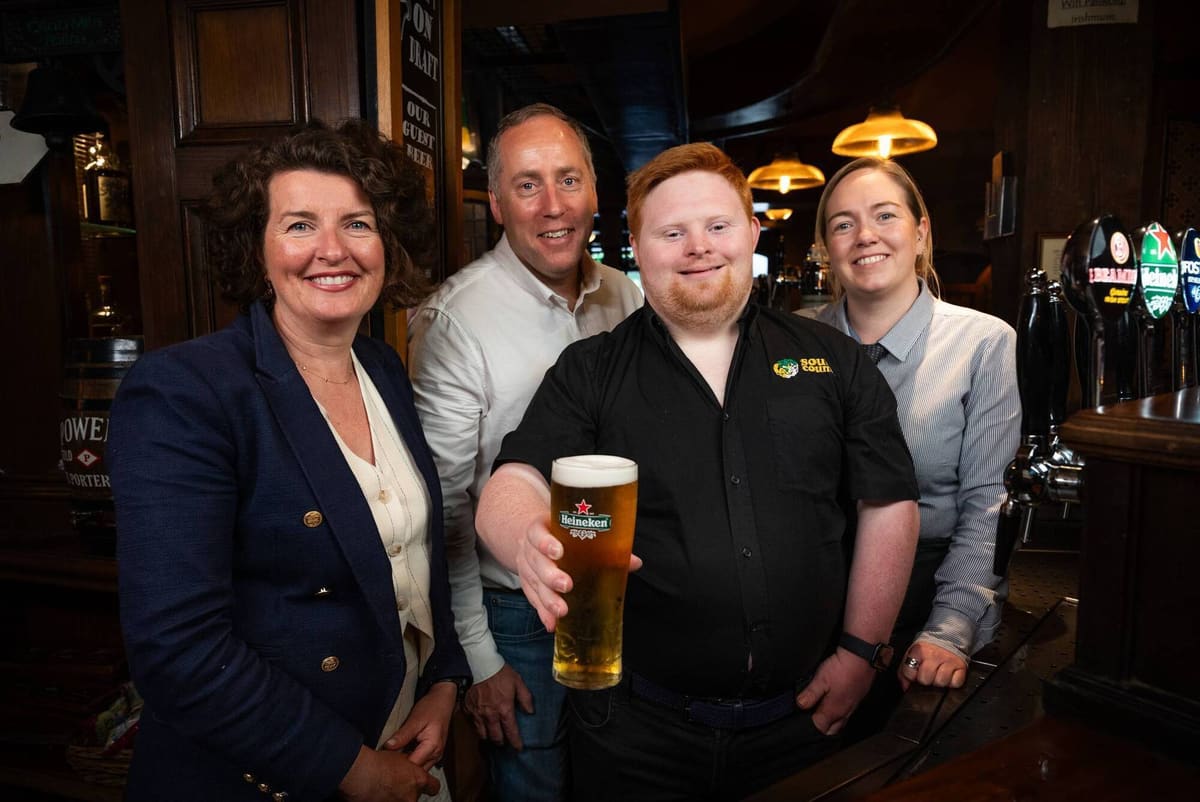 Dylan behind the bar at the South County in Douglas, with his manager Sarah and colleagues