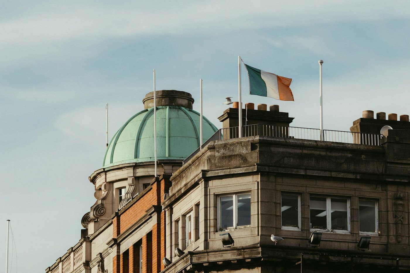 A green domed public building flying the Irish flag